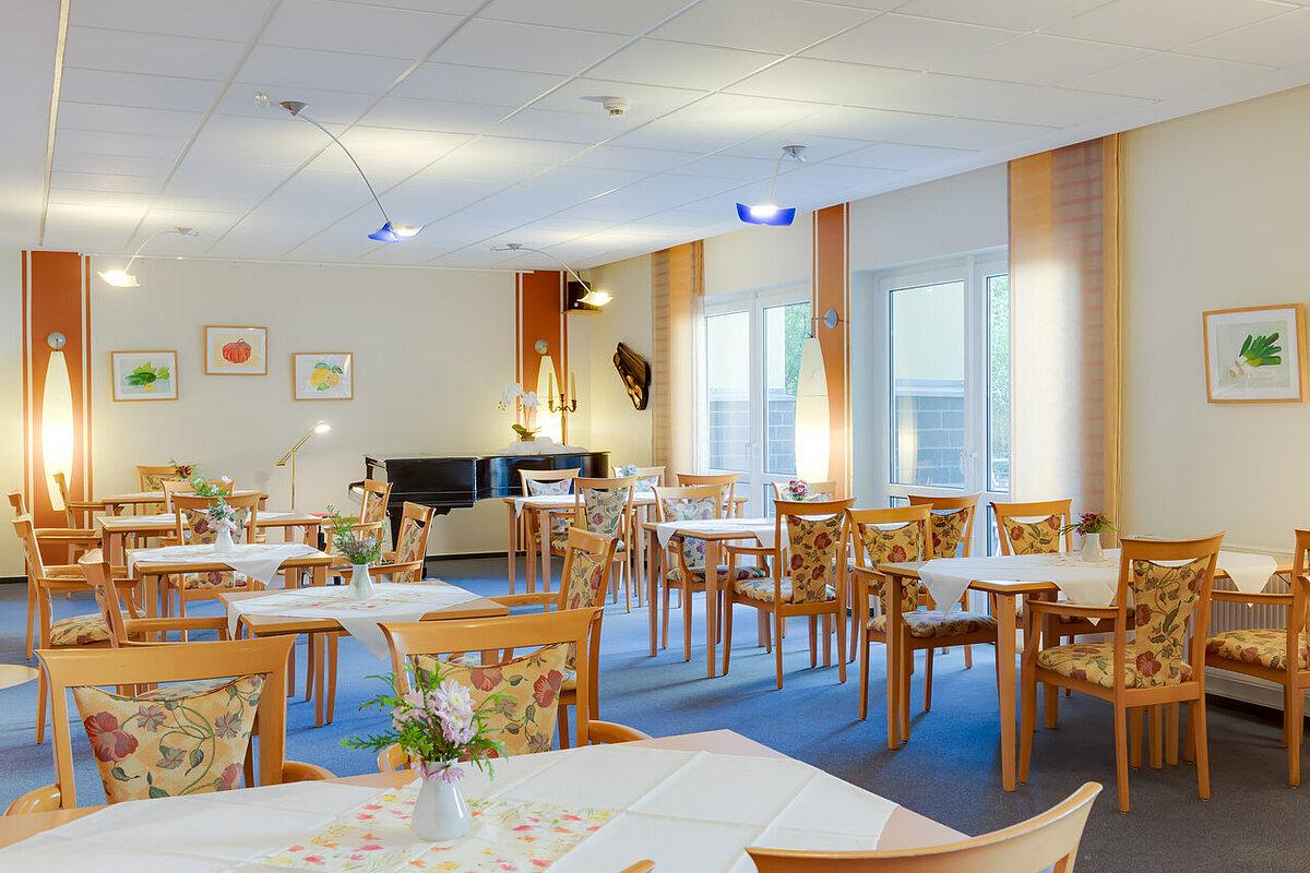 Speisesaal Tische und Stühle mit Klavier im Hintergrund