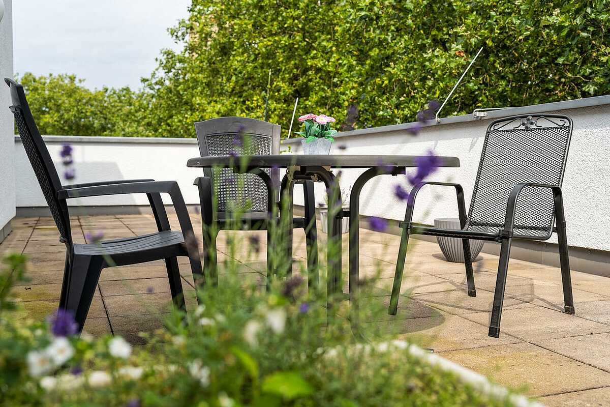 Tisch mit Stühlen auf dem Balkon unseres CMS Pflgeheims