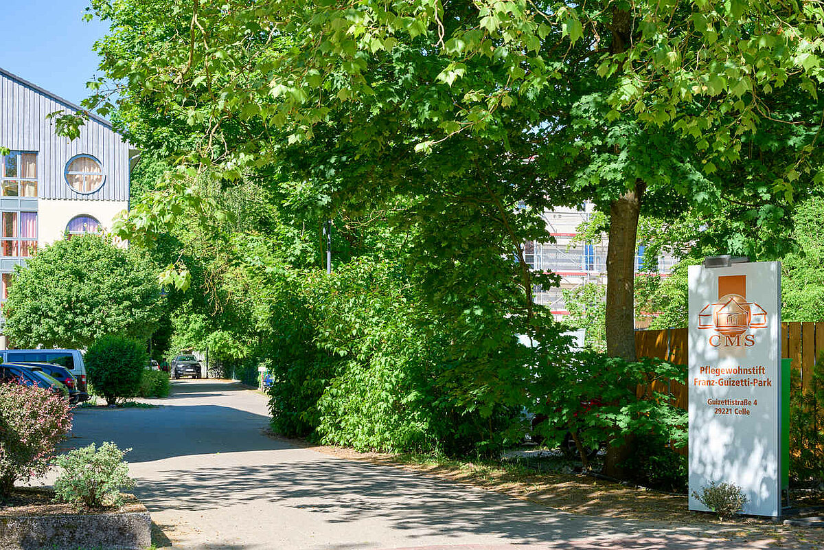 CMS Standort-Schild unter Bäumen auf einem Parkplatz